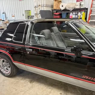 Black classic coupe with tinted windows, in the shop.