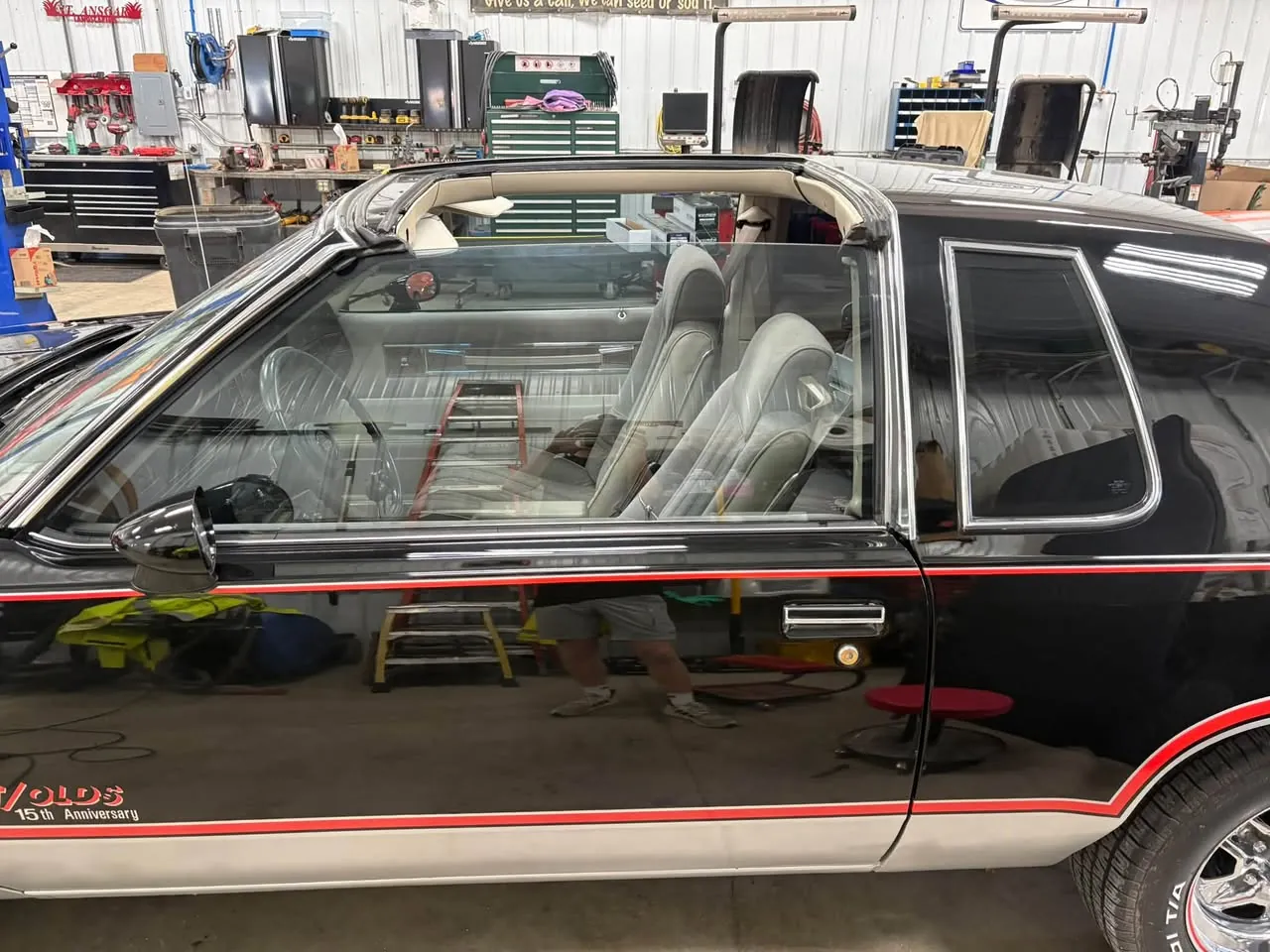 Black classic coupe with tinted side windows, in the shop.