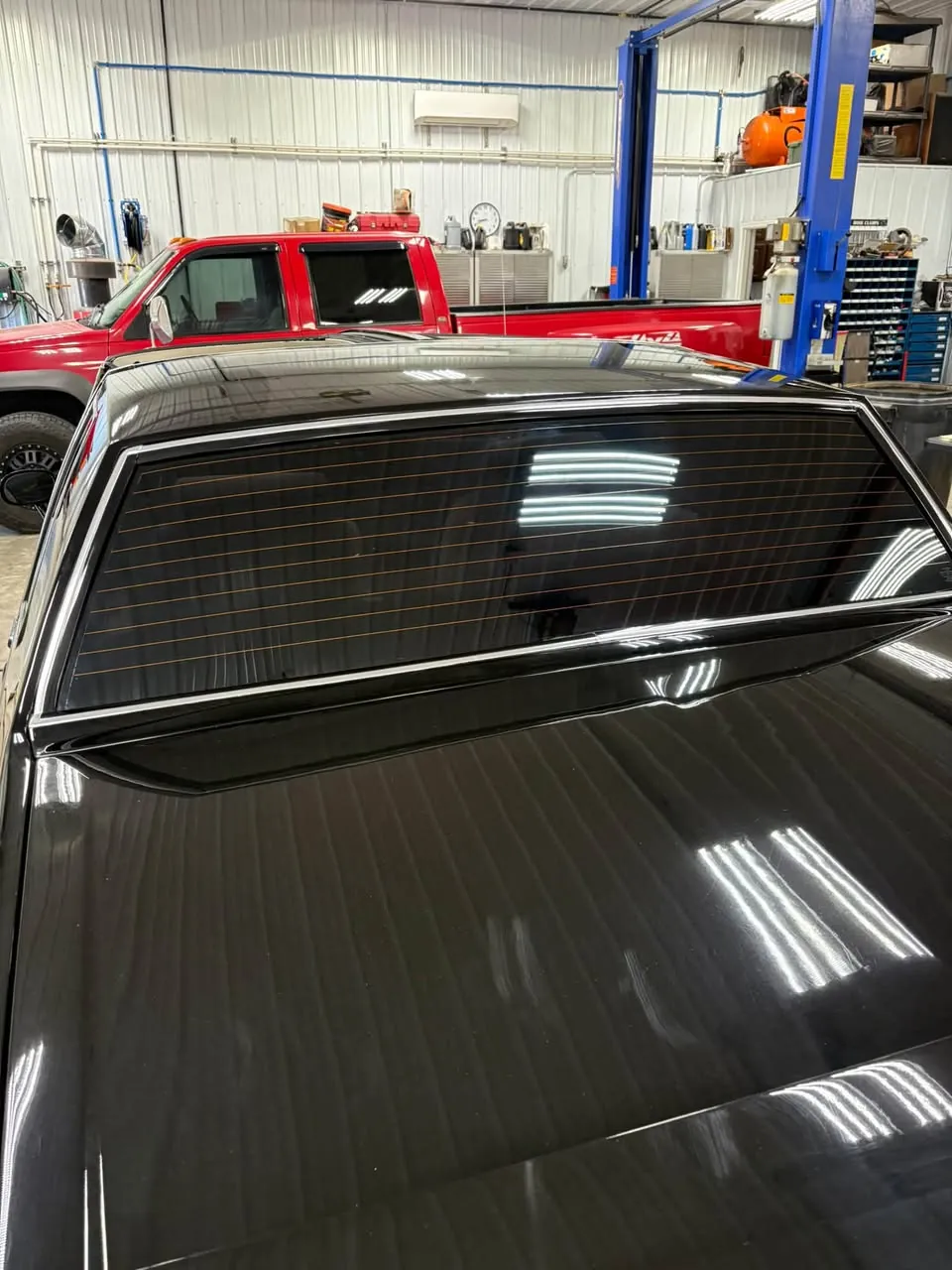 Tinted rear glass of a black car.
