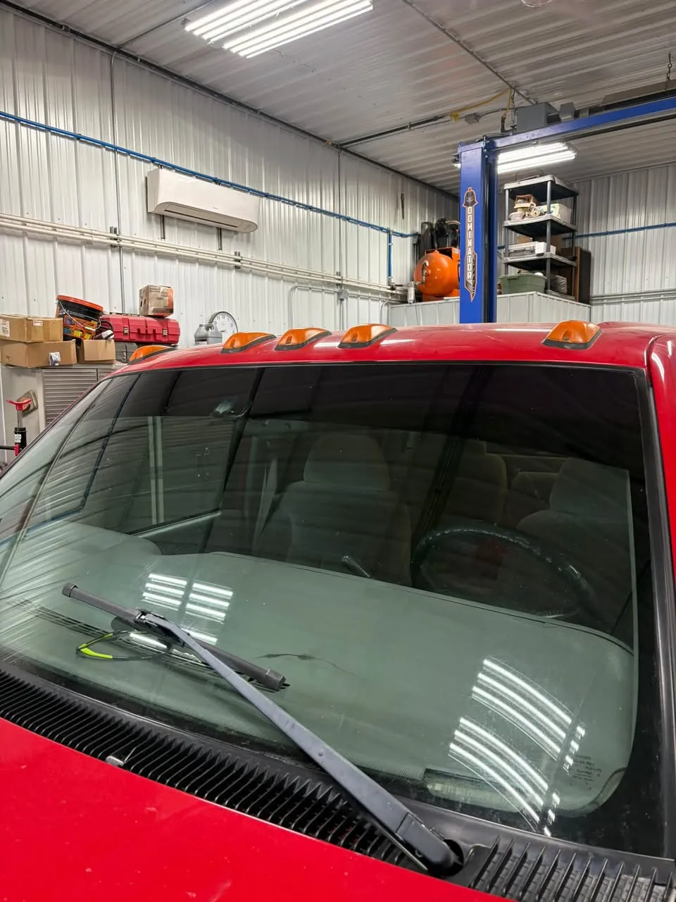 Red pickup from the front, tinted cab windows.